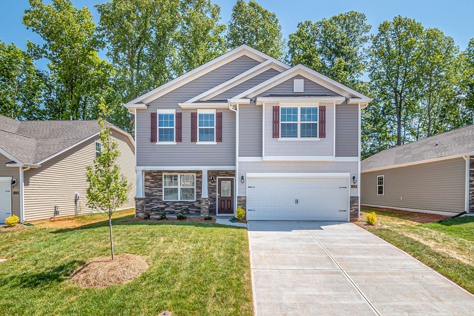 Wide concrete driveway with control joints beside a house